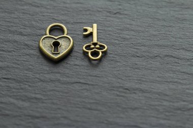 Bir kayrak taş arka plan üzerinde anahtar ile Kalp şeklinde asma kilit . kalp kavramından anahtar