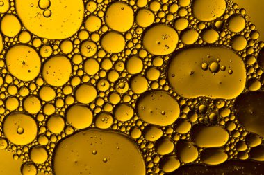 Soyut sarı su kabarcıkları arka planda. Makro atış. Yağ kabarcıkları kapanıyor. 