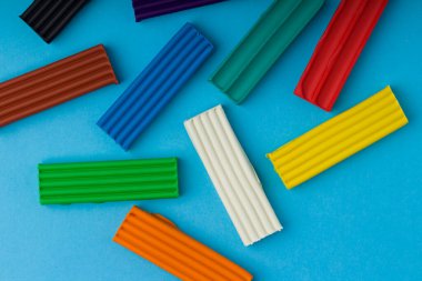 Mavi arkaplanda renkli plastik çubuklar seti.