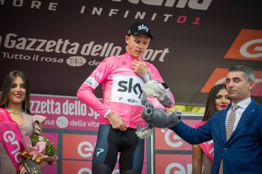 Bardonecchia, İtalya 25 Mayıs 2018: Chris Froome, pembe Jersey gökyüzü takım İtalya Bisiklet turu 2018 yokuş yukarı bir yüzey ile en zor aşaması zaferle Bardonecchia podyumda kutluyor.