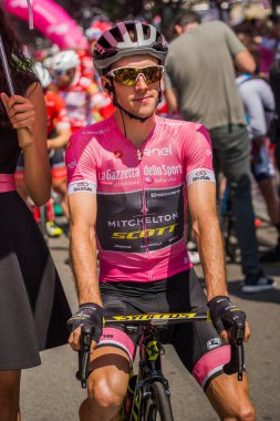Abbiategrasso, İtalya 24 Mayıs 2018: Pembe Jersey'de Simon Yates, başlamadan önce Tur İtalya 2018 Abbiategrasso ve Prato Nevoso varış sert dağına aşamasında ilk satırı.
