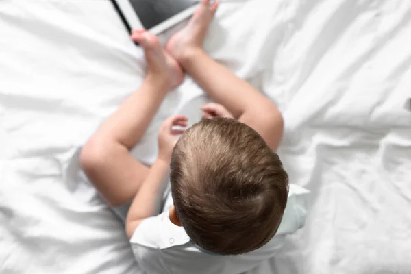 Fiú Fejét Ült Egy Ágyon Fehér Ágyneművel Játszott Tabletta Felülnézet — Stock Fotó