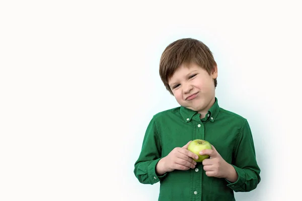 Menino Uma Camisa Verde Segura Uma Maçã Verde Suas Mãos — Fotografia de Stock