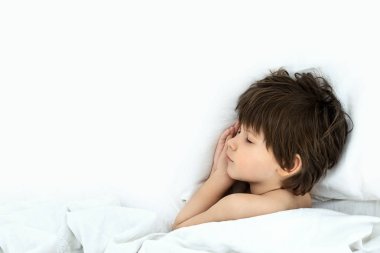 çocuk uyku, çocuk beyaz bir yatak örtüsü bir yatakta yatıyor. Üstten Görünüm. 