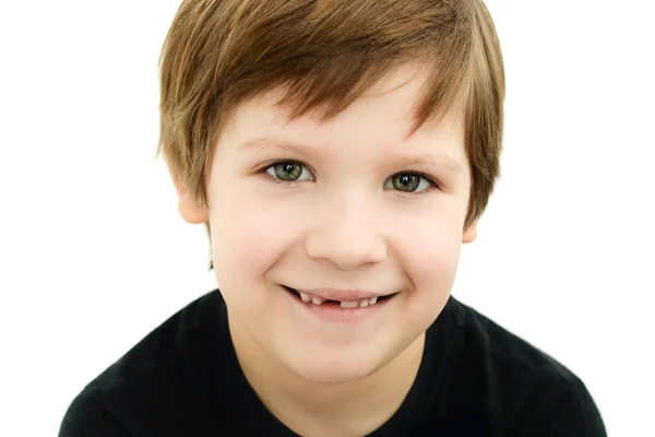 Niño sonriente sin un diente de bebé sobre un fondo blanco — Foto de Stock