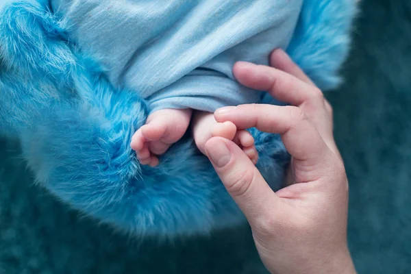 Pies de un bebé recién nacido, dedos de los pies en las manos de mamá y papá, manos y uñas de un niño, los primeros días de vida después del nacimiento, piel escamosa —  Fotos de Stock