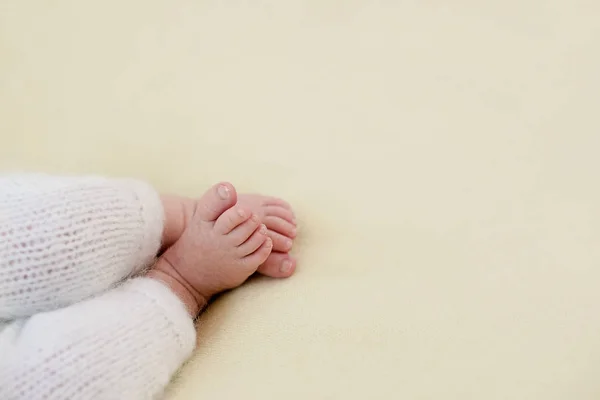 Ноги новонародженої дитини, пальці ніг в руках мами і тата, руки і нігті дитини, перші дні життя після народження, лупа шкіри — стокове фото