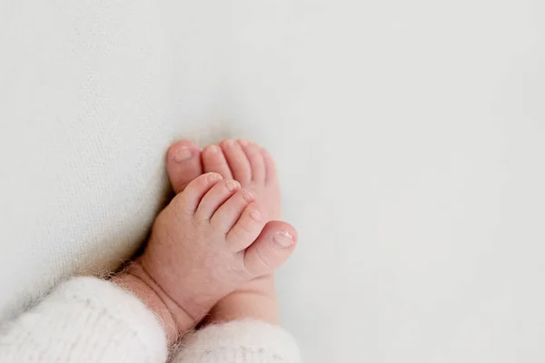 Pés de um bebê recém-nascido, dedos dos pés nas mãos de mãe e pai, mãos e unhas de uma criança, os primeiros dias de vida após o nascimento, pele escamosa — Fotografia de Stock