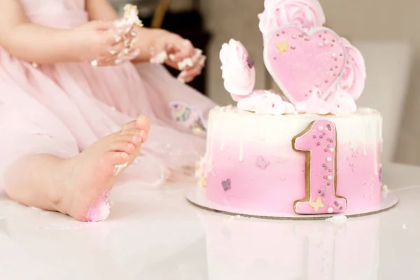 Bater bolo rosa na celebração do primeiro aniversário da menina, bolo de esponja em ruínas, marshmallow quebrado, 1 ano — Fotografia de Stock