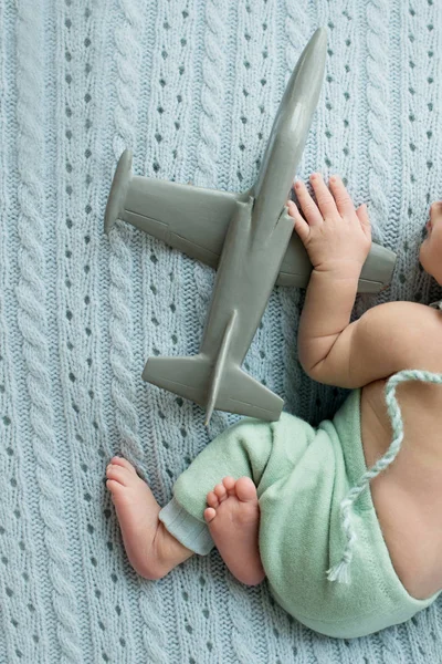 Niño recién nacido con un avión de juguete en sus manos , — Foto de Stock