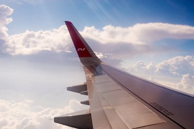 Moskova, Rusya, 8 Temmuz 2019. Nordwind logosu ve bulutları olan bir Boeing 'in kanadındaki logodan görüntü. uçak yolculuğu.