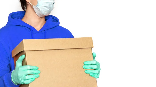 非接触式递送 一个戴着医疗面罩和手套的男人拿着一个盒子 复制空间 Coronavirus隔离 在线交付产品和货物 — 图库照片