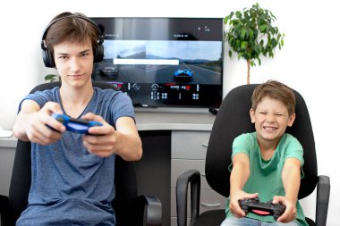 Genç çocuk internet üzerinden kulaklık, joystick ve oyun konsoluyla bilgisayar oyunu oynuyor..
