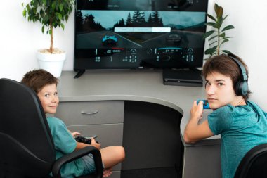 Orenburg, Rusya, 19 Haziran 2020. Büyük gerçekçilik sporu. Ergen, kulaklık, joystick ve oyun konsoluyla bilgisayar oyunu oynuyor..