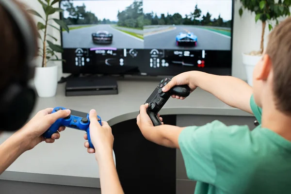 Orenburg, Rusia, 19 de junio de 2020. Sony Playstation 4. Gran truismo deportivo. Adolescente juega un juego de ordenador con auriculares y un joystick, consola de juegos . —  Fotos de Stock