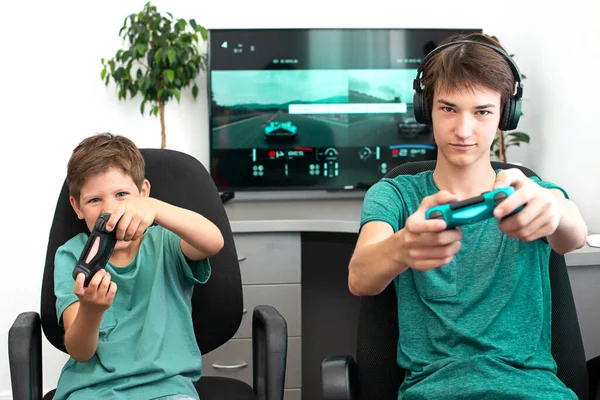 Orenburg, Russia, 19, June 2020. Sony Playstation 4. Gran truism sport. Teenager plays a computer game with headphones and a joystick, game console. — Stock Photo, Image