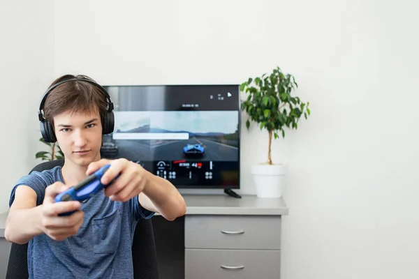 Orenburg, Russie, 19 juin 2020. Sony Playstation 4. Gran truisme sport. Adolescent joue à un jeu d'ordinateur avec un casque et un joystick, console de jeu. — Photo