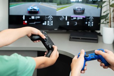 Genç çocuk internet üzerinden kulaklık, joystick ve oyun konsoluyla bilgisayar oyunu oynuyor..