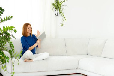 Kız telefonda konuşuyor. Evde gülümseyen gerçek bir kadın. Beyaz iç kısım, boşluğu kopyala.