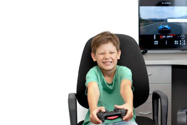 Genç çocuk internet üzerinden kulaklık, joystick ve oyun konsoluyla bilgisayar oyunu oynuyor..