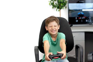 Genç çocuk internet üzerinden kulaklık, joystick ve oyun konsoluyla bilgisayar oyunu oynuyor..