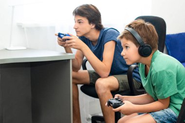 Teenager boy online plays a computer game with headphones and a joystick, game console. clipart