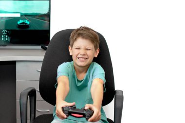 Genç çocuk internet üzerinden kulaklık, joystick ve oyun konsoluyla bilgisayar oyunu oynuyor..