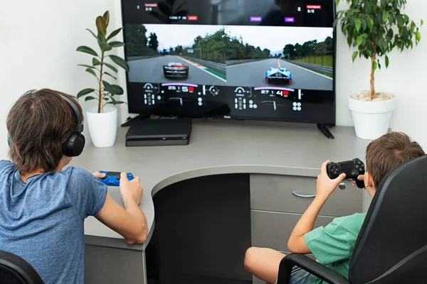 Genç çocuk internet üzerinden kulaklık, joystick ve oyun konsoluyla bilgisayar oyunu oynuyor..