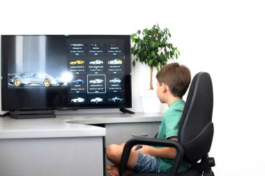Genç çocuk internet üzerinden kulaklık, joystick ve oyun konsoluyla bilgisayar oyunu oynuyor..