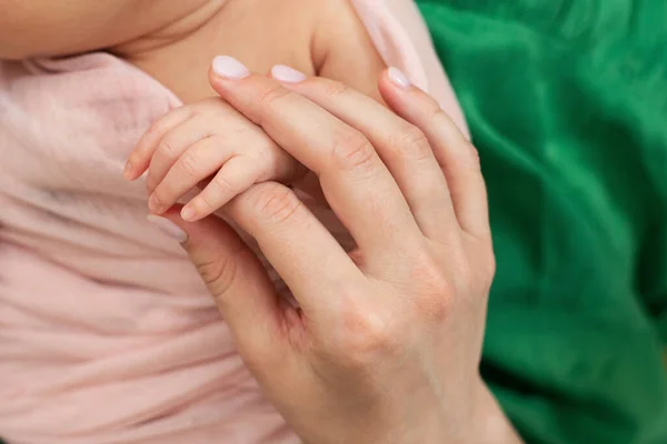 Mamá sostiene la mano de un bebé recién nacido. Amor y ternura. Día de las Madres. — Foto de Stock