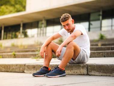 Genç ve çekici bir sporcu antrenmandan sonra dinleniyor - egzersiz konsepti