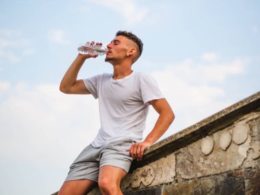 Eğitimden sonra su içen çekici genç bir sporcu - spor konsepti