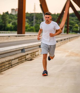 Genç ve çekici bir sporcu dışarıda antrenman yapıyor.