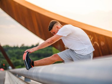 Genç ve çekici bir sporcu dışarıda antrenman yapıyor.