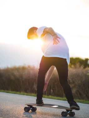 Açık havada kaykay süren yakışıklı beyaz bir erkeğin yüzeysel odak noktası.