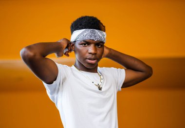 Sarı arka planda genç siyah bir erkeğin sığ odak noktası.