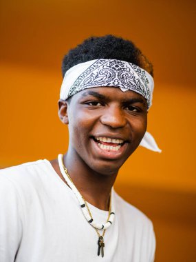 Sarı arka planda genç siyah bir erkeğin sığ odak noktası.