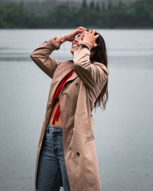 Genç bir kadın yaya köprüsünde tek başına duruyor ve göle bakıyor. Suyun üzerinde sis. Sisli hava. Soğuk bir sabah. Arka plan.