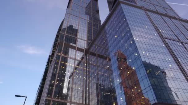 Rascacielos modernos hechos de vidrio. Vista panorámica desde abajo con rotación — Vídeos de Stock