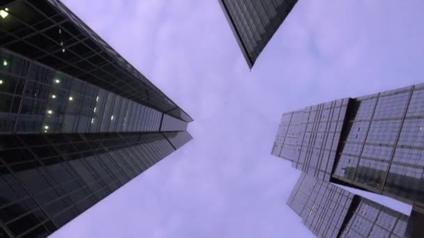 Low angle shot of camera rotating in front of modern, skyscrapers. Daytime