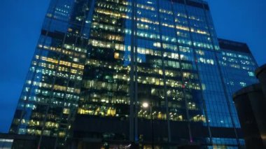 Camdan yapılmış olağandışı şeklin modern gökdelenler. Alt görünüm. Akşam