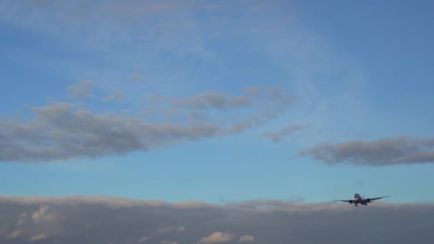 Commerciële vliegtuigen vliegt overhead tegen de blauwe lucht en de prachtige wolken — Stockvideo