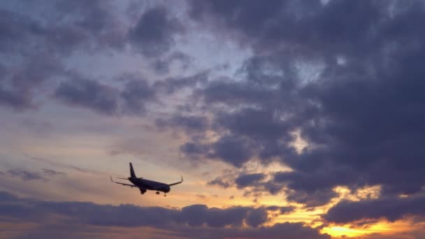 Passagerarplan flyger overhead. Solnedgången i bakgrunden. UltraHD arkivfilmer — Stockvideo
