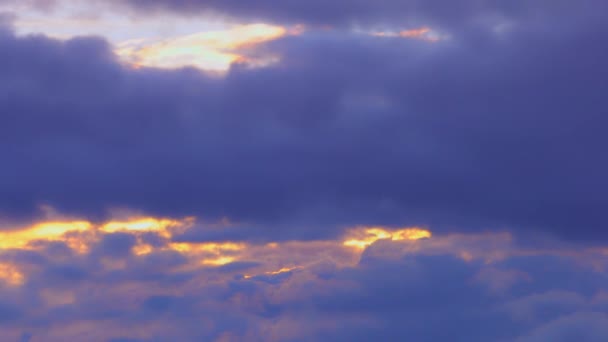 Gouden zon breken door donker blauwe pluizige snel passeren wolken 4k timelapse — Stockvideo