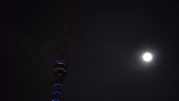 Oberteil des futuristischen Fernsehturms. im Hintergrund dunkler Himmel, Wolken und Vollmond — Stockvideo