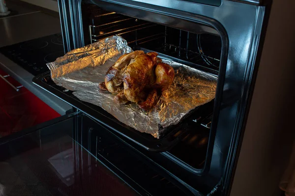 Delicious roasted Turkey in the oven. In the background kitchen Stock Image