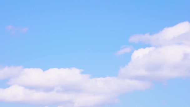 Norii albi de fundal sunt cerul albastru însorit. 4k timelapse. Partea 1 din 3 — Videoclip de stoc