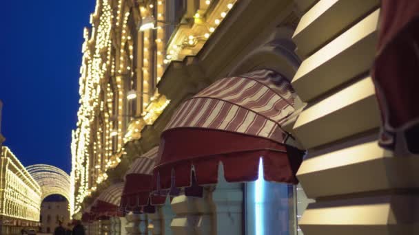 Facade of a building is decorated with illuminations. Canopies over shop windows — Stock Video