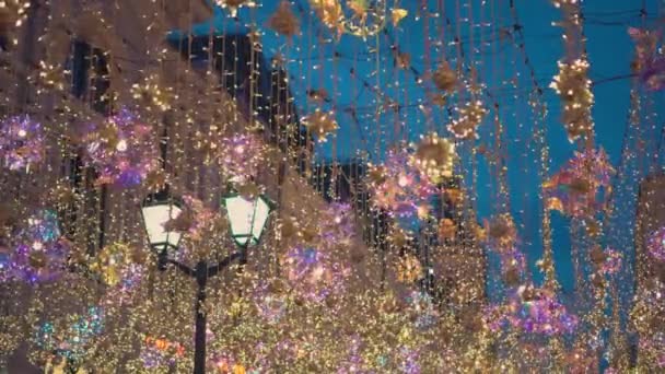 Farola, decoraciones navideñas, guirnaldas, un gran número de luces brillantes — Vídeo de stock