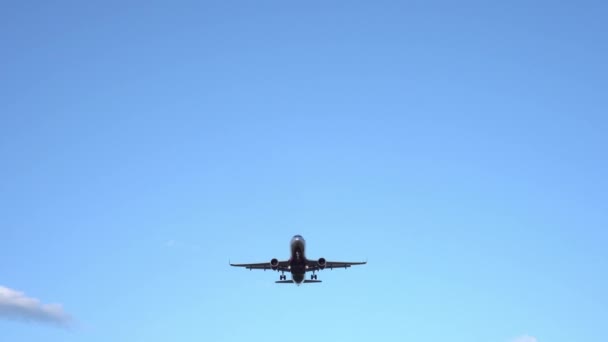 Avião de passageiros moderno voa em cima, exatamente no centro da moldura. 4K — Vídeo de Stock